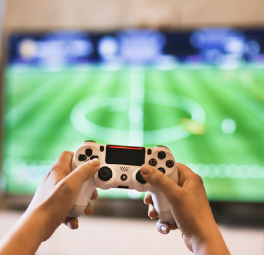 テレビゲームのコントローラーを握る手元。